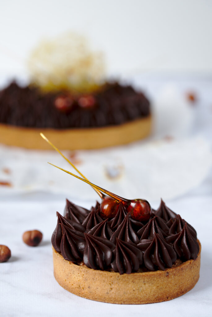 Picture of an individual tarte piemontaise with larger tarte piemontaise in background