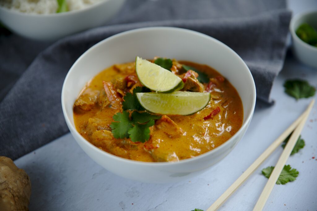 bowl of red curry with lime slices